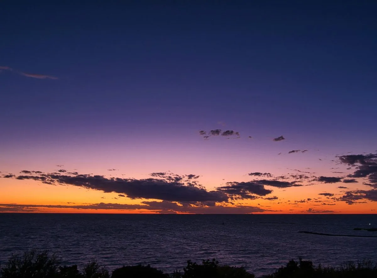 Sunset over Lake Huron at Goderich, a band of orange under a dark purple sky.