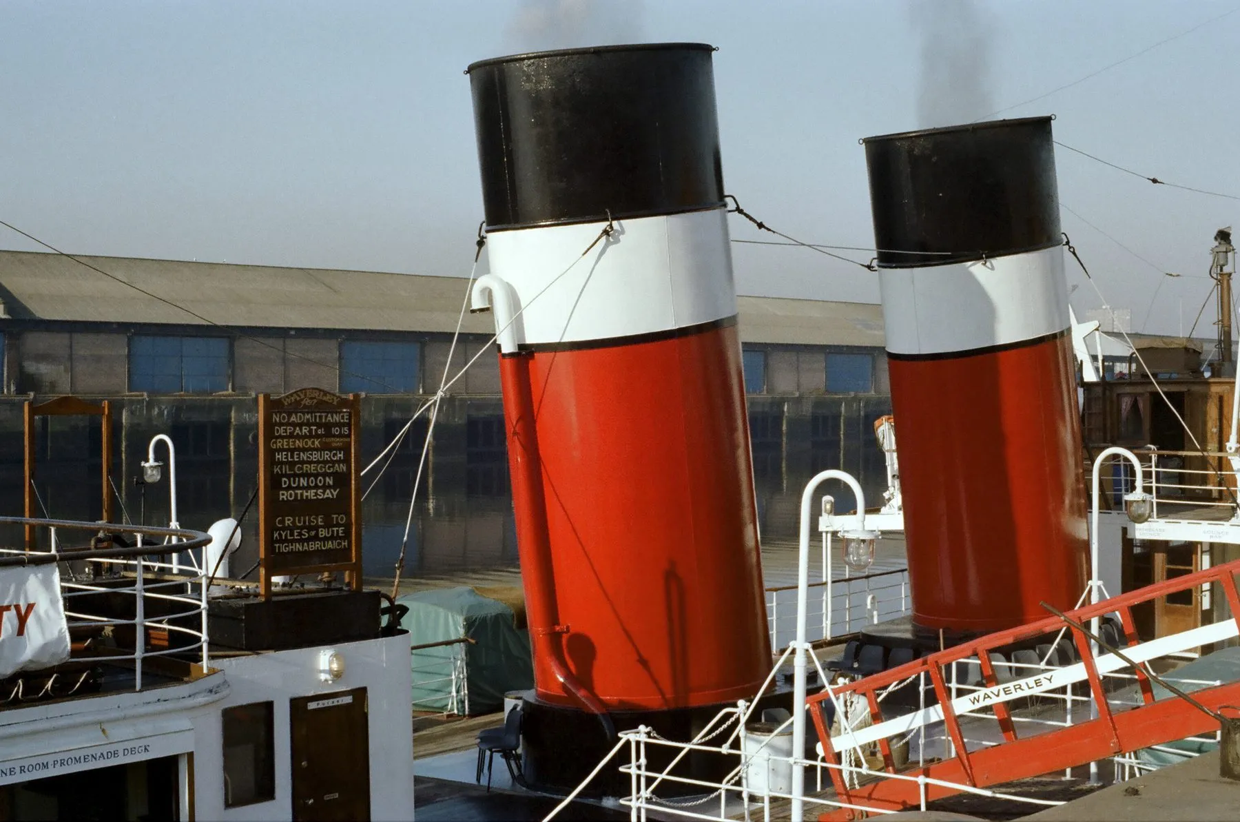 Waverley’s two funnels, painted red with a white band and a black top, seen from the quay.
