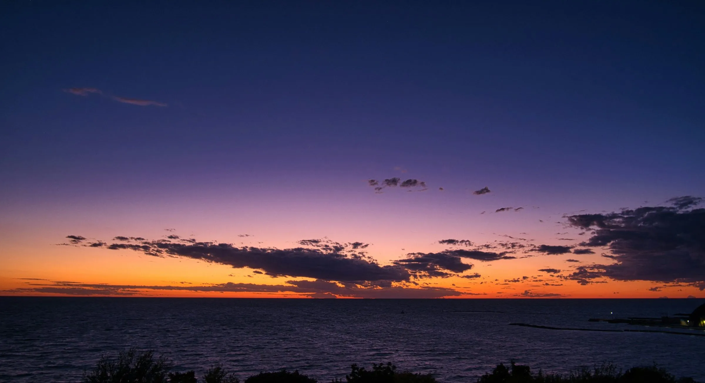 Sunset over Lake Huron at Goderich, a band of orange under a dark purple sky.