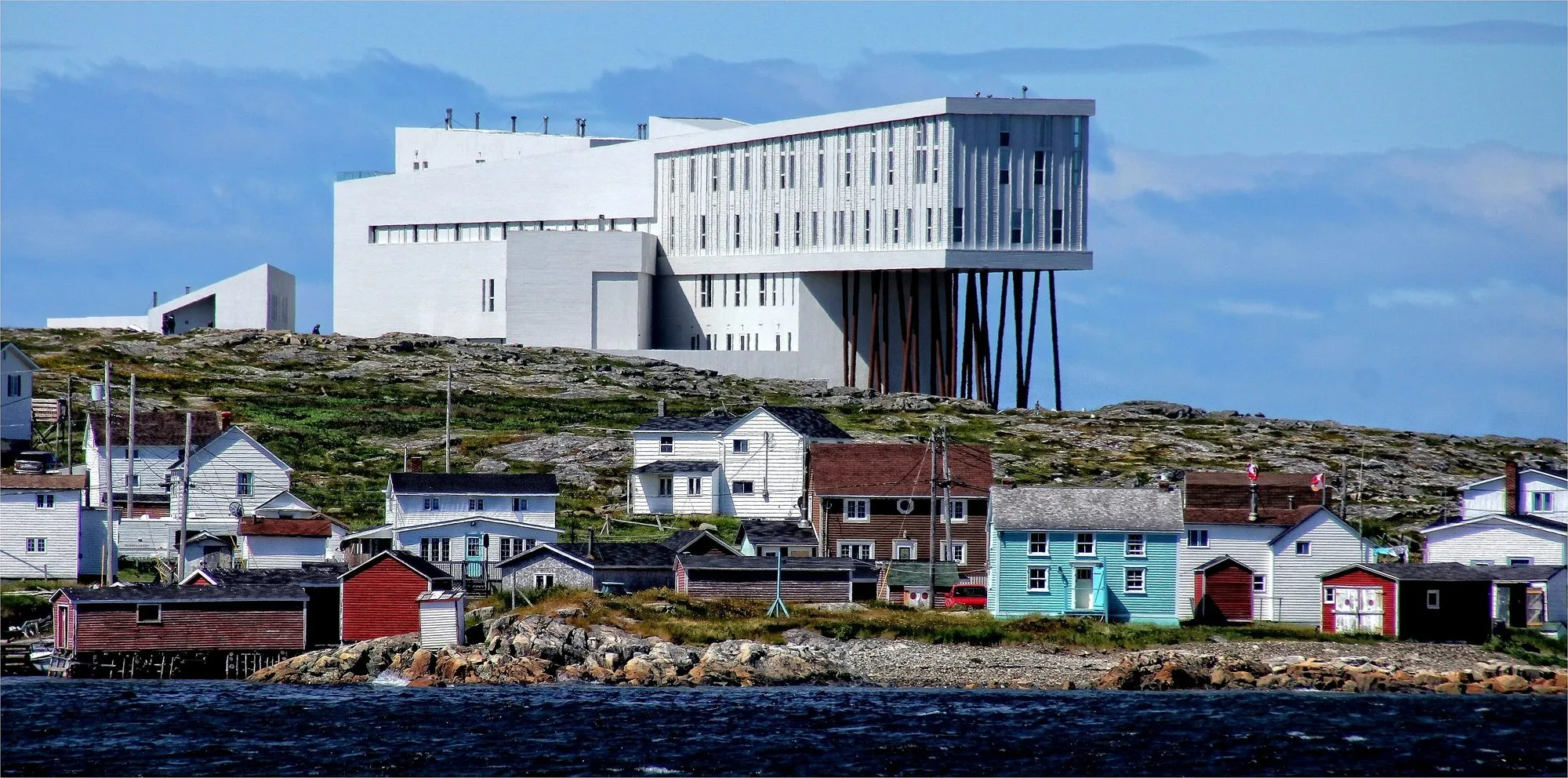 The white Fogo Island Inn on its steel legs, standing above the small painted houses of Joe Batt’s Arm.