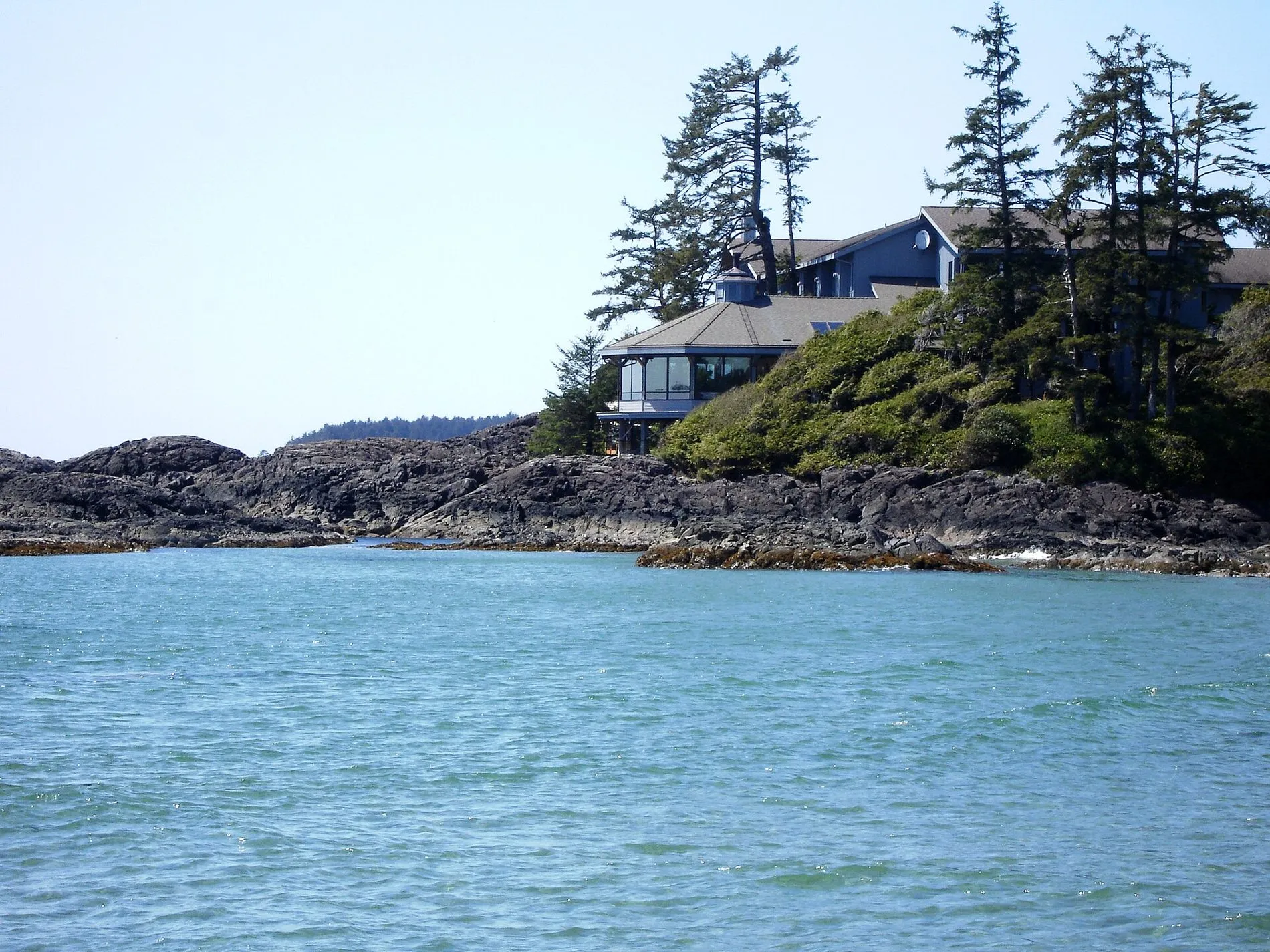 The Wickaninnish Inn, a low cedar building among wind-bent trees on a rocky point above the sea.